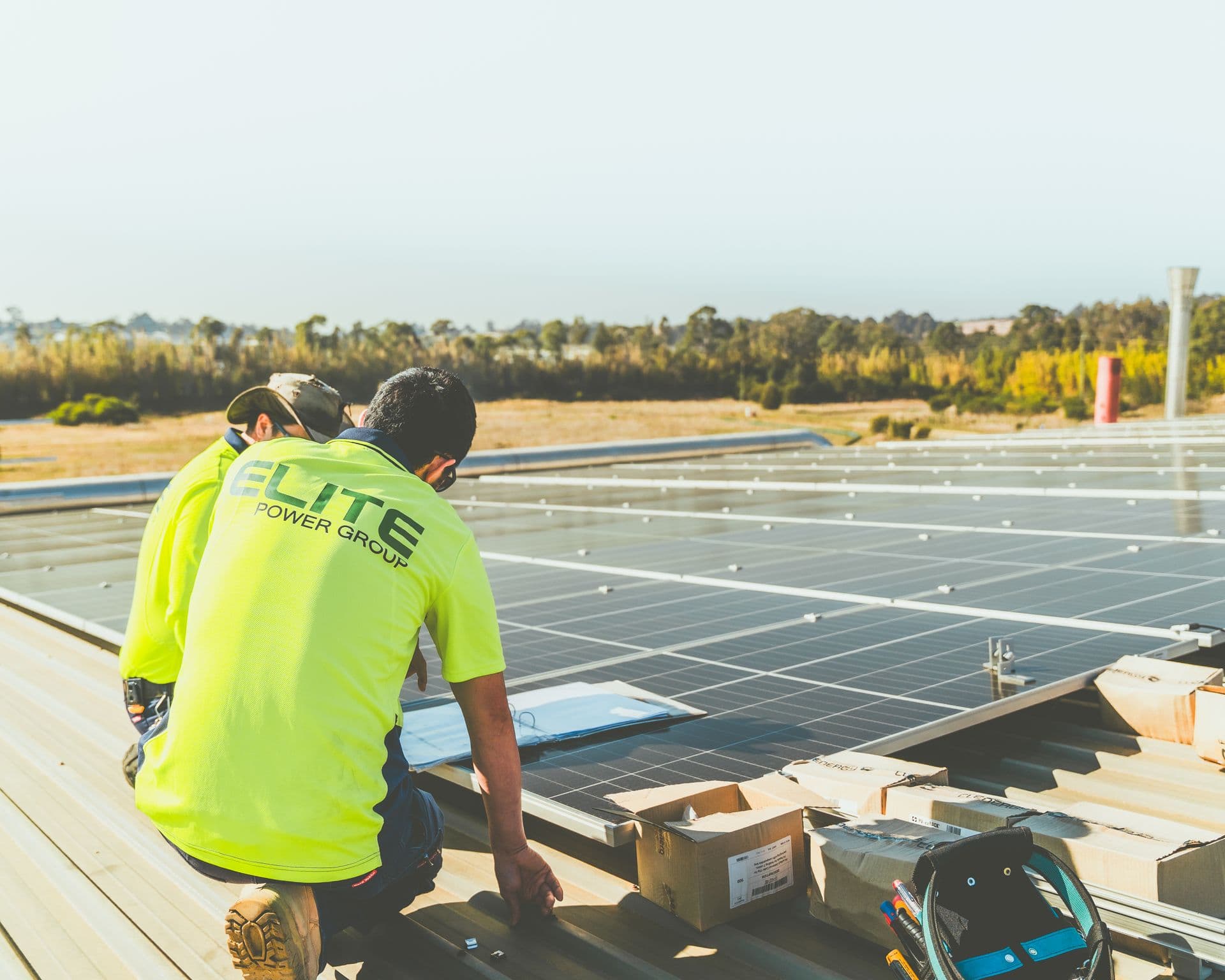 Technicians installing a commercial rooftop solar array